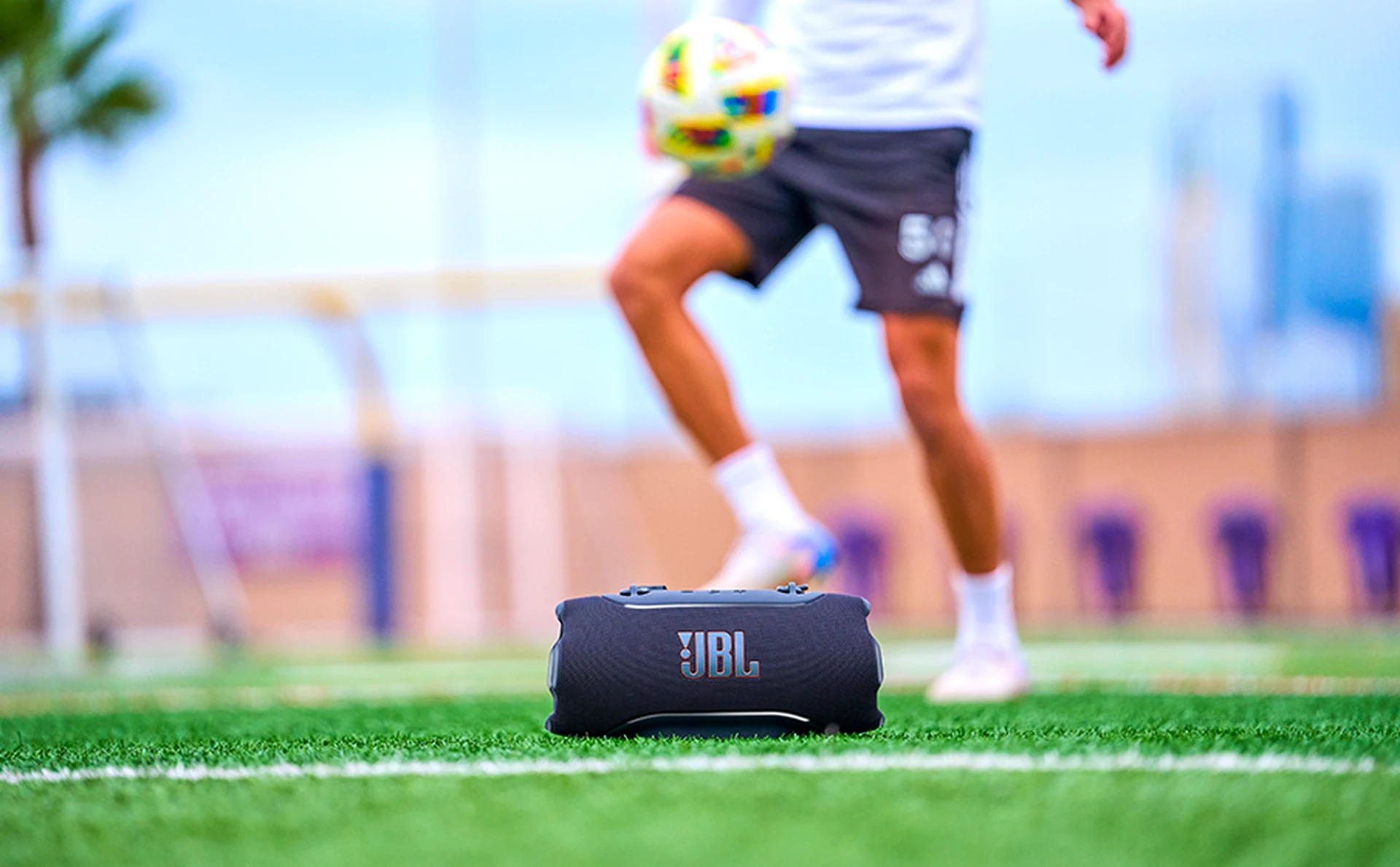 JBL Xtreme 5 portée au bord d’un terrain de sport