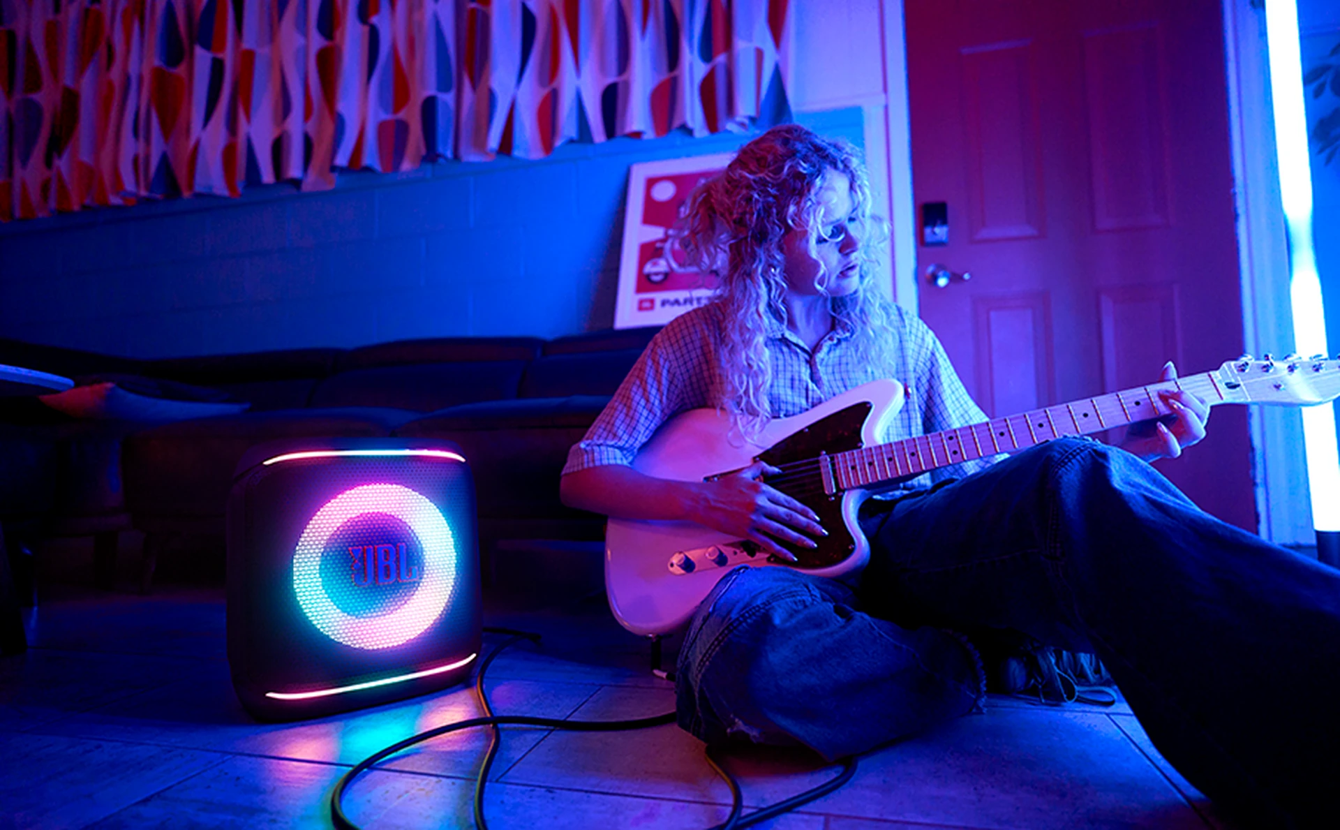 Musicienne à la guitare accompagnée d’une JBL PartyBox Encore 2